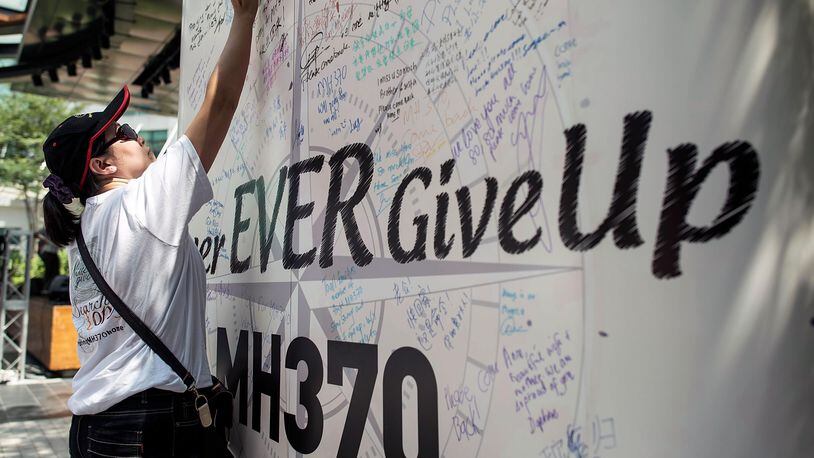 FILE PHOTO:  A family member of victim of MH370 plane crash writes a on a message board during a memorial event MH370 Day of Remembrance at The Square of Publika on March 8, 2015 in Kuala Lumpur, Malaysia. March 8th, 2015 marks exactly one year of Malaysia Airlines Flight MH370 went missing. The plane is believed to have crashed in southern part of Indian Ocean has yet to be found.  (Photo by Anthony Kwan/Getty Images)
