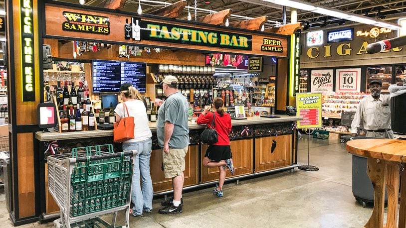 Customers stand at the beer and wine tasting bar at Jungle Jim’s International Market Friday, July 6, 2018, in Fairfield. NICK GRAHAM/STAFF