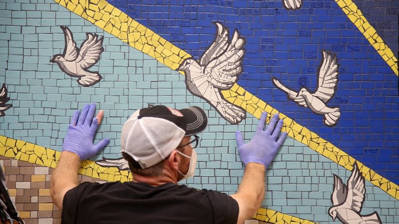 '9 Doves,' a mosaic mural created by the community to honor the nine people killed in the Oregon District mass shooting last year, was hung Tuesday, Aug. 3 in the lobby of City Hall. LISA POWELL / STAFF