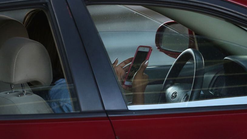 A driver uses a phone while behind the wheel of a car on April 30, 2016 in New York City. (Photo by Spencer Platt/Getty Images)