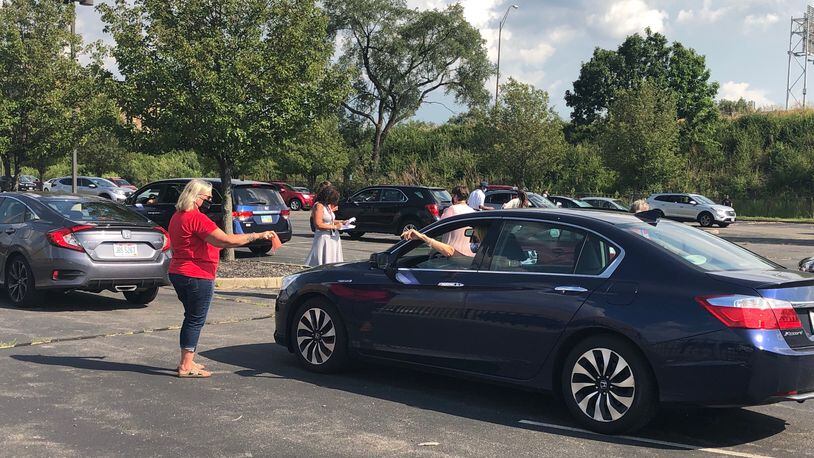 Hundreds of Dayton teachers union members participated in a drive-thru vote  Monday, Aug. 24, 2020, at Ponitz Career Technology Center that is connected to Dayton Public Schools' upcoming layoffs plan.