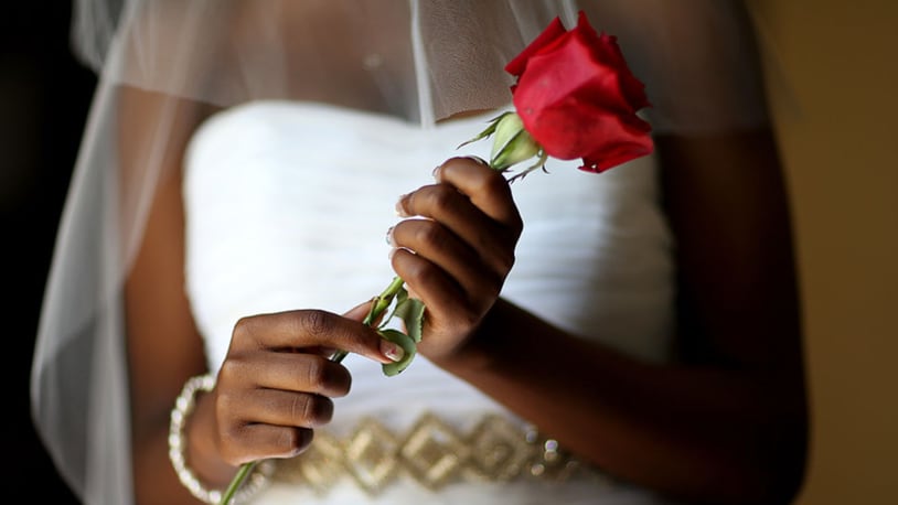 A bride holds a rose as she waits to be wed. (Photo by Joe Raedle/Getty Images)