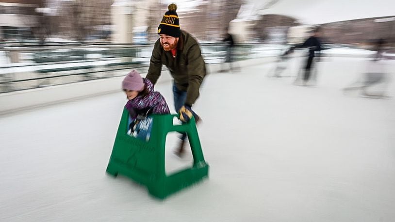 John Bulfin and his daughter, Blaine cruise around the Metroparks ice rink at Riverscape Tuesday December 27, 2022. The Bulfin family is visiting family in Dayton over the holidays. JIM NOELKER/STAFF