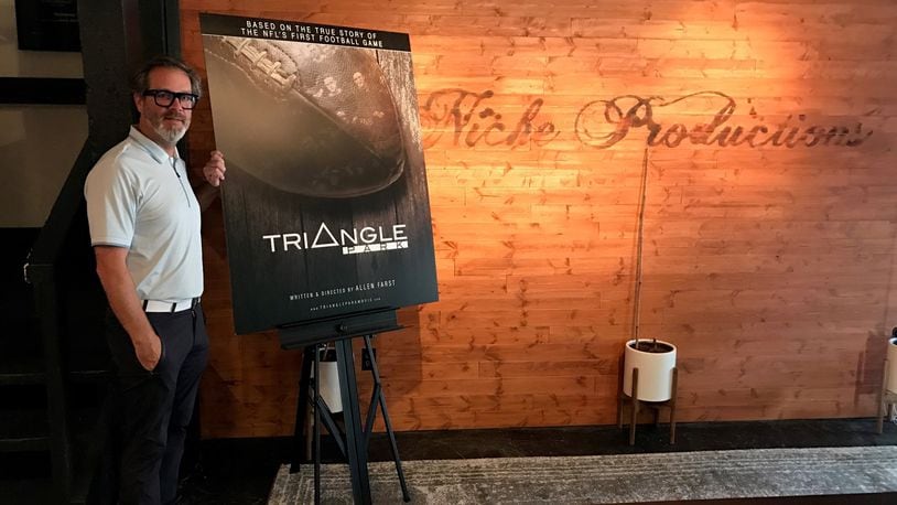 Local filmmaker Allen Farst at his Niche Production headquarters in Centerville with a poster for his upcoming documentary, “Triangle Park,”  and the NFL’s first-ever game, played right here in Dayton by the Dayton Triangles and the Columbus Panhandles at Triangle Park in 1920. Tom Archdeacon/STAFF