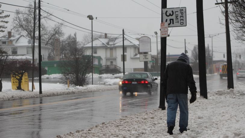 A man walks along North Main as cars drive past traveling well above the posted speed limit of 35 mph. CORNELIUS FROLIK / STAFF