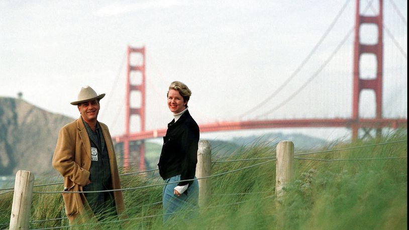 FILE - In this March 30, 1998, file photo, Larry Harvey, left, and Marian Goodell, two of the founders of the Burning Man festival walk near Baker Beach in San Francisco with the Golden Gate Bridge in the background. Harvey, the co-founder of the "Burning Man" festival has died. He was 70. Burning Man Project CEO Marian Goodell says Harvey died Saturday, April 28, 2018, morning at a hospital in San Francisco. The cause was not immediately known but he had suffered a stroke on April 4. Harvey created Burning Man on a San Francisco beach in 1986, later moving the annual event to Nevada's Black Rock Desert. (AP Photo/Eric Risberg, File)