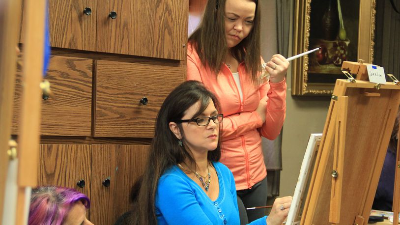 Olde Masters galleria owner Cecilia Brendel works with students at the Centerville galleria.