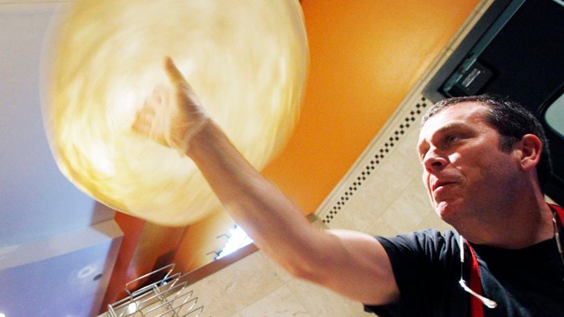 In this file photo from 2011, Glen Brailey, founder and owner  of Spinoza's Pizza & Salads prepares pizza dough at the restaurant inside the Mall at Fairfield Commons.