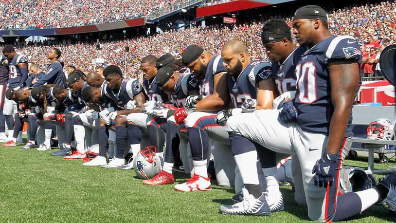 Members of the New England Patriots kneel during the National Anthem before a game against the Houston Texans (Photo by Jim Rogash/Getty Images)