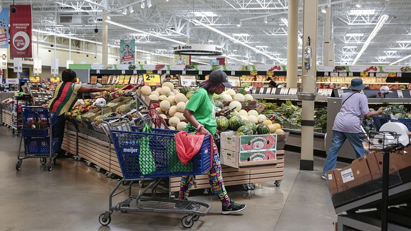Shipt shopper Gina Moorman of Detroit, center, scans through her shopping list as she walks through the produce section at Meijer, Thursday, June 22, 2017 in Detroit. (Junfu Han/Detroit Free Press/TNS)