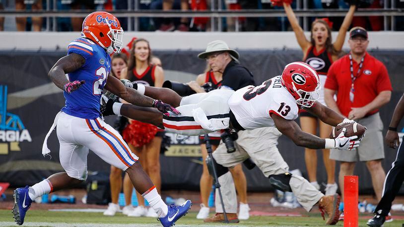 2017 File photo:  Elijah Holyfield #13 of the Georgia Bulldogs dives into the end zone for a 39-yard touchdown in the fourth quarter of a game against the Florida Gators at EverBank Field on October 28, 2017 in Jacksonville, Florida. Georgia defeated Florida 42-7. (Photo by Joe Robbins/Getty Images)