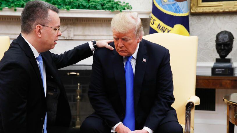 President Donald Trump prays with American pastor Andrew Brunson in the Oval Office of the White House, Saturday October 13, 2018, in Washington.