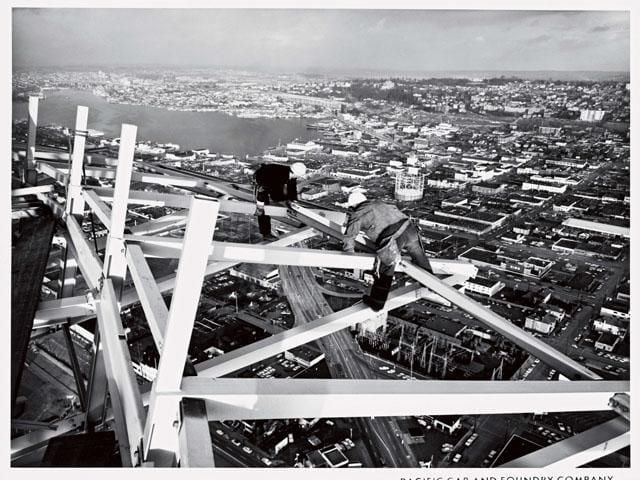 "Fearless construction workers check the joists on the Space Needle's halo."