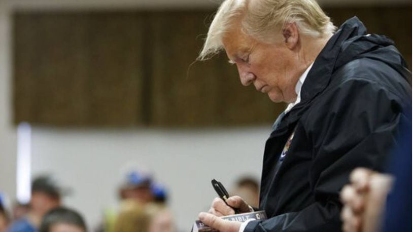 President Donald Trump signs a Bible during his visit to a church in Lee County, Alabama, on Friday.