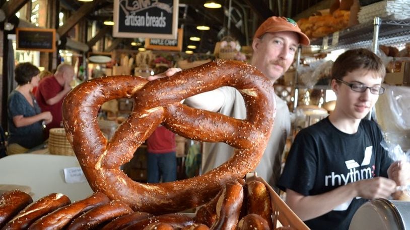 Rahn Keucher holds up one of his giant Pretzels at his Rahn's Artisan Breads retail booth at the 2nd Street Market in downtown Dayton in 2013.