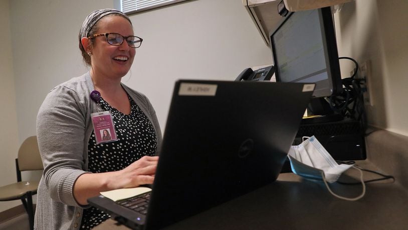 Nurse Practitioner Ashley Mowen talks with a patient on the computer during a telehealth visit at the Rocking Horse Center Wednesday. BILL LACKEY/STAFF