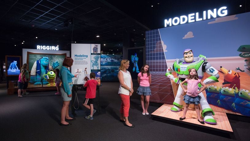 Visitors pose with human-sized models of some of their favorite Pixar characters, including Buzz Lightyear and Mike & Sulley. CONTRIBUTED