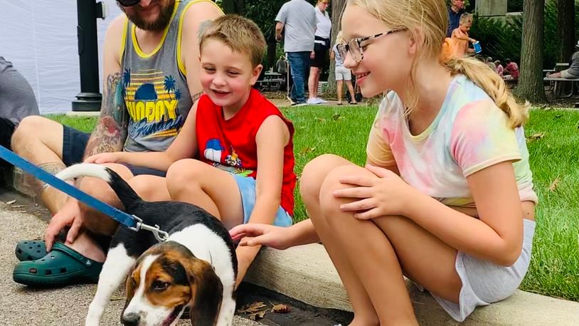 Hudson and Harper Waitukaitis are greeted by a very friendly beagle at the 2022 Holiday at Home festival. LONDON BISHOP/STAFF