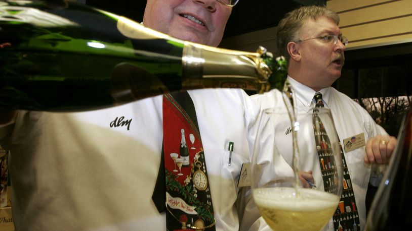 In this file photo, George Punter, (left) manager of beer and wine for Dorothy Lane Market’s Washington Square store, serves Champagne at a special DLM tasting. FILE