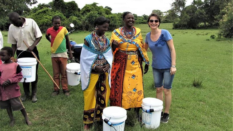 Narcisa Mikov (in blue) with villagers in Kenya. The white buckets are distributed with easy to use water filters that last for many years.