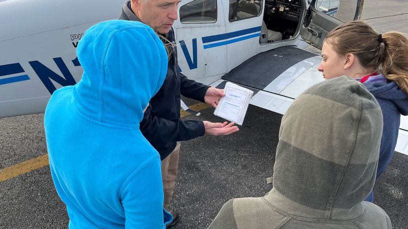 Flight instructor Tom Casey reviews a pre-flight checklist with students at an Air Camp session at the Lewis Jackson Airport in Xenia on Nov. 5. THOMAS GNAU/STAFF