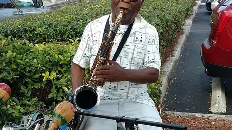 Oladepo Ogomodede plays jazz in the parking lot of a Florida shopping center.