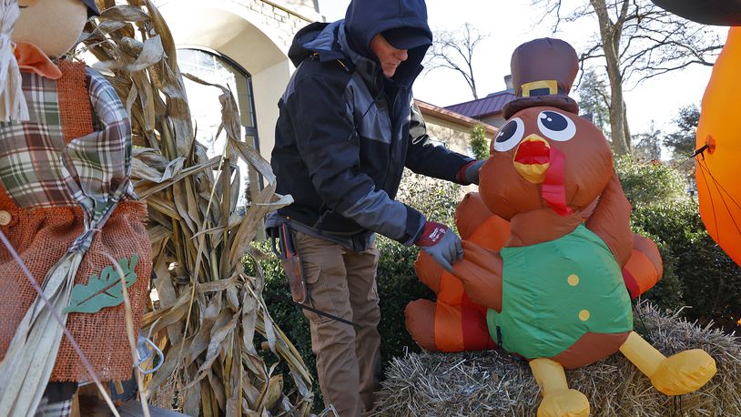 George Roach, from George's Landscaping, sets a Thanksgiving turkey inflatable back up in front of the Madison Avenue Pharmacy Monday, Nov. 21, 2022. According to Roach, the wind has played havoc with the inflatable decorations this season and he's had to set them back up and anchor them with extra string several times. BILL LACKEY/STAFF