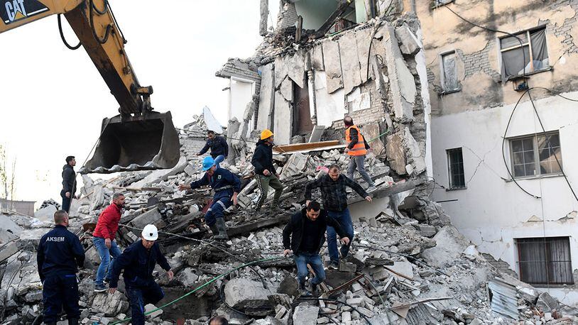 Emergency workers clear debris at a damaged building in Thumane, about 20 miles northwest of capital Tirana, after an earthquake hit Albania on Nov. 26, 2019.