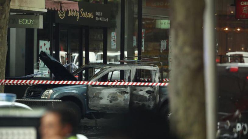A burned vehicle is shown in the central Melbourne shopping district after a stabbing took place Friday.