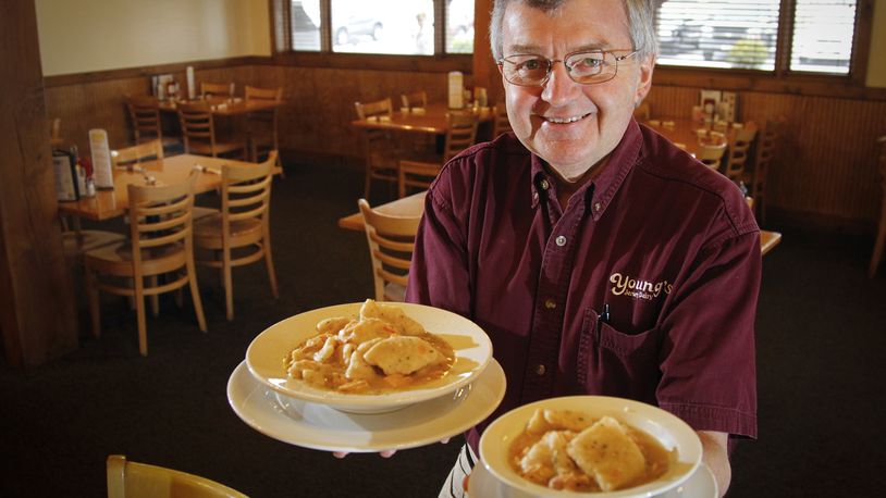 In this 2013 photo, Dan Young, owner of Young's Jersey Dairy and the Golden Jersey Inn in Clark County north of Yellow Springs, serves two sizes of chicken and dumplings. Young said Sunday that the Golden Jersey Dairy, which has been shut down since March 2020 due to the coronavirus pandemic, will not reopen as a full-service restaurant, but will instead be transformed into events space to be called Young's Events Center. File photo by LISA POWELL / STAFF