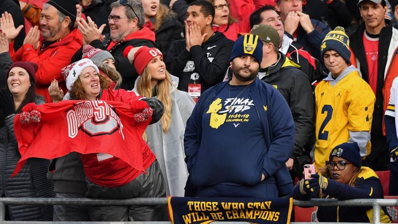 COLUMBUS, OH - NOVEMBER 24:  Ohio State fans celebrate in the fourth quarter after the Buckeyes added another touchdown as Michigan Wolverines fans watch at Ohio Stadium on November 24, 2018 in Columbus, Ohio. Ohio State defeated Michigan 62-39.  (Photo by Jamie Sabau/Getty Images)