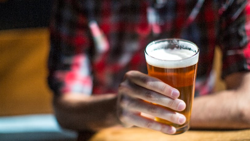 Man holds beer (JTobiasonPhoto / iStock / Getty Images Plus)