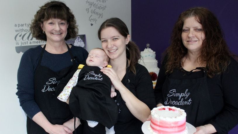 Jackie Fuller (center), her mom, Adonica Collins-Smith (right) , and mother-in-law, Debby Fuller (left), opened Simply Decadent in August at 108 West Franklin St. in Bellbrook. They are pictured with Jackie's newborn baby, Aria.