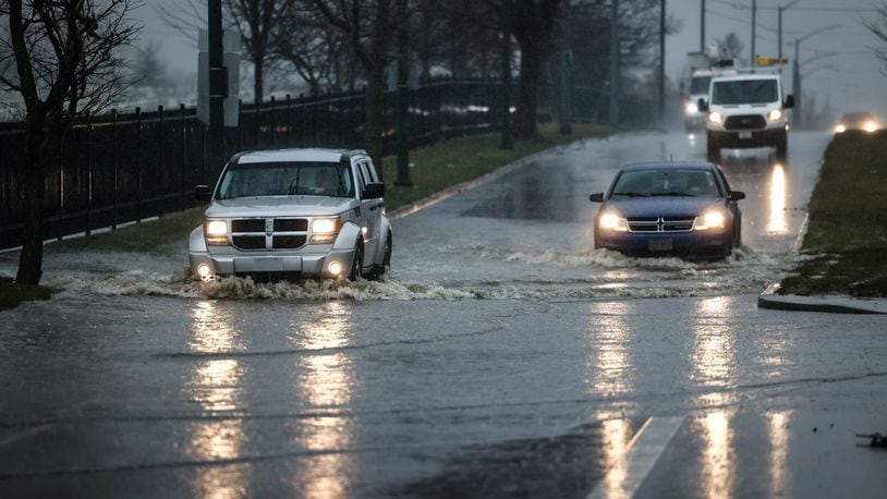 Motorists roll through deep water on southbound Gettysburg Ave. in front of the Dayton National Cemetery Friday March 3, 2023. Since this photo was taken, southbound has closed. JIM NOELKER/STAFF