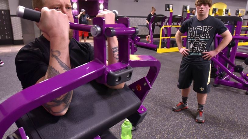 Ryan Patrick curls as his son Macaden Patrick, 15, watches at the new Planet Fitness in Middletown’s Towne Mall Galleria in January 2016. The nearly 27,000 square foot facility has over 110 pieces of cardio equipment, each with a 15-inch tv, tanning beds, hydromassagers, free weights, weight machines and more. NICK GRAHAM/STAFF