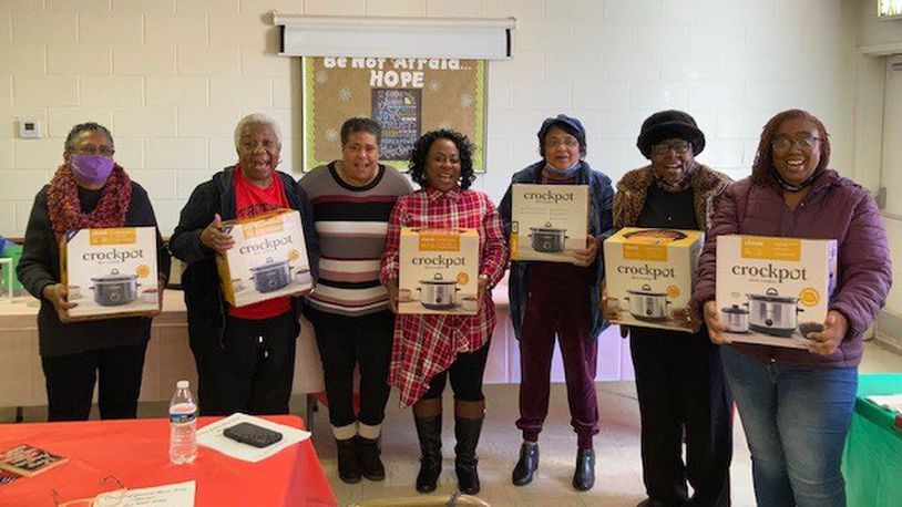 Eva Wells, third from left, also known as "The Crock Pot Lady" gives away crock pots to community members in her crock pot cooking classes.