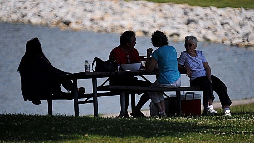 FILE PHOTO: Picnicking at Delco Park in the shade of the trees by the pond is a nice way to stay cool on a warm day as from left, Kaityln Oswald, Mike Oswald, Kathlyn Hollopeter and Leatrice Freiberg demonstrate. Staff Photo/Marshall Gorby