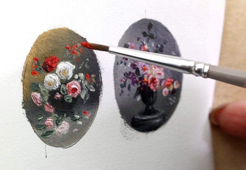 Cecilia Brendel uses delicate brushes and a magnifying glass for the detailed work of her miniature oil paintings.  LISA POWELL / STAFF