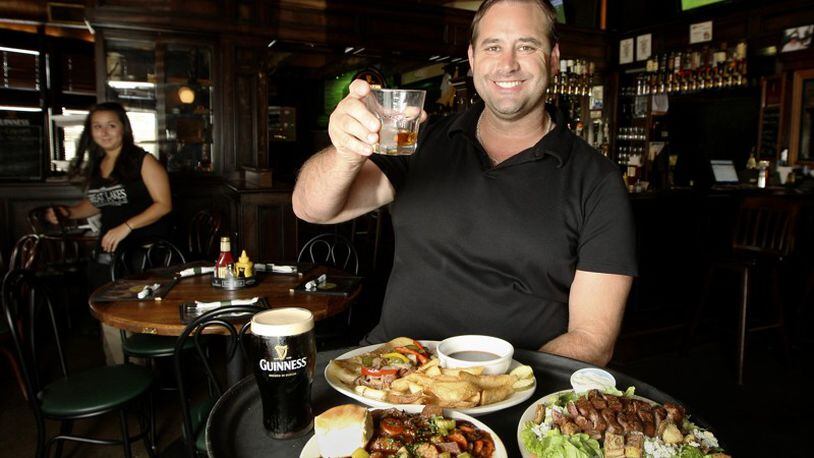 Steve Tieber, co-owner of the Dublin Pub. Pictured are three entrees: (clockwise from front) Guiness Beef Stew, the Black and Bleu Salad, and the Irish Dip sandwich with fries. STAFF/FILE