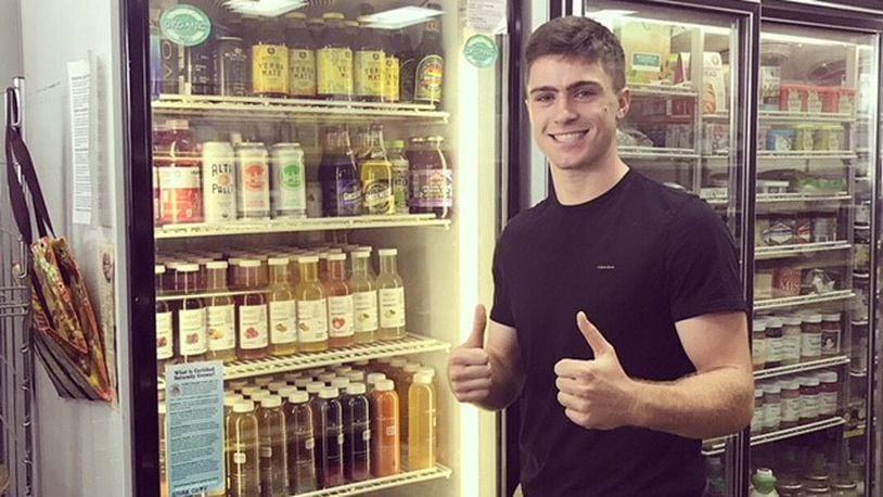 Luke West poses with drinks by WestWood Organics stocked on a store shelf. WestWood is aiming to open in Kettering later this year. CONTRIBUTED