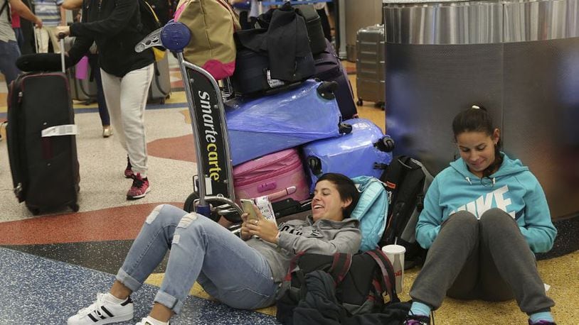 Yanina Fernandez, left, and her sister Liz, wait for an available flight to Argentina after their flight was cancelled at Miami International Airport, Thursday, Sept. 7, 2017, in Miami. South Florida officials are expanding evacuation orders as Hurricane Irma approaches, telling more than a half-million people to seek safety inland. (AP Photo/Marta Lavandier)