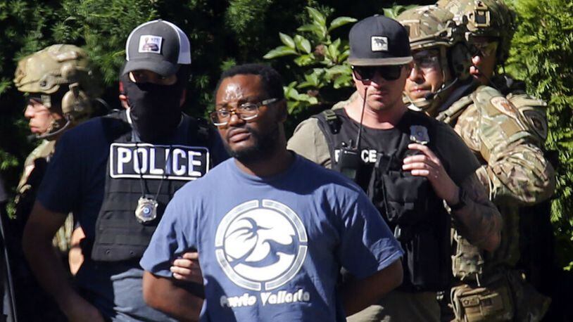Salt Lake City police take Ayoola A. Ajayia, 31, into custody Friday. He was arrested and charged with aggravated  murder, kidnaping and desecration of a body in the death of  University of Utah college student MacKenzie Lueck, police said.