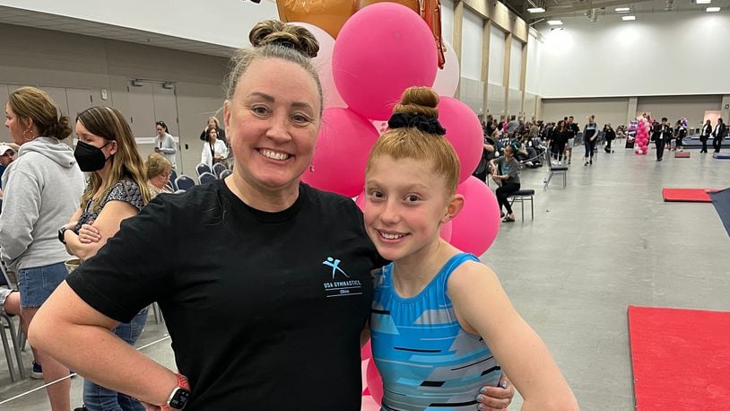LaPeer (L) with one of her gymnasts, Emma Doherty. Doherty had surgery to repair a broken arm last year and LaPeer made sure she took the "Smurf" good luck charm with her to surgery.