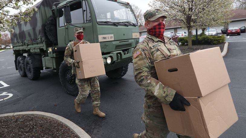 Ohio Army National Guardsmen, Sgt Kyle Smith, left, and Spc Logan Wilson deliver boxes of food to elderly residents in New Carlisle in April. BILL LACKEY/STAFF