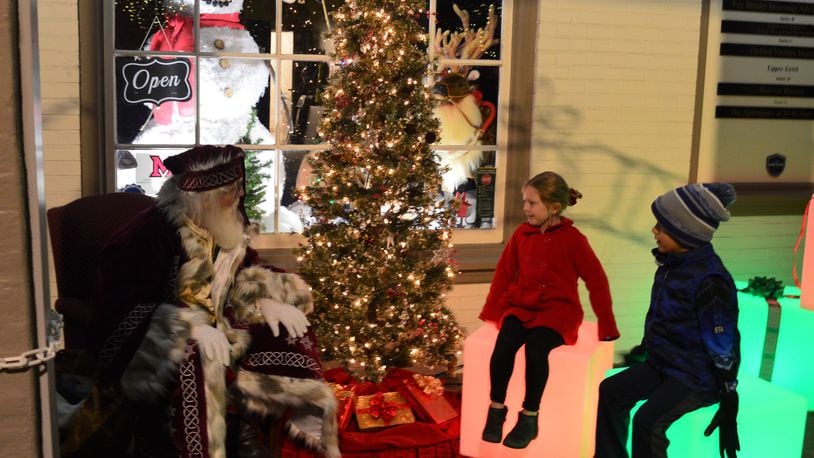 FILE/2021: Santa Claus met with kids to hear their holiday wishes during the evening of the Holiday Festival. The visits were held outside in front of a festive window at Enjoy Oxford. CONTRIBUTED/BOB RATTERMAN