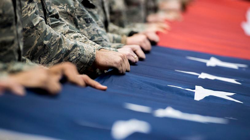 FILE: Airmen from Wright-Patterson Air Force Base, Ohio, hold a large, garrison-size American flag at half court during pregame ceremonies prior to the NCAA First Four Tournament at the University of Dayton Arena in Dayton, Ohio, March 14, 2018. During the game’s halftime events, Lt. Gen. Robert McMurry Jr., Air Force Life Cycle Management Center commander, also administered the oath of enlistment to delayed enlistment to 32 personnel. (U.S. Air Force photo by Wesley Farnsworth)