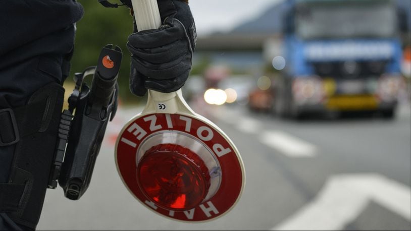 A German police officer holds a stop sign as he observes traffic Sept. 14, 2015, near Bad Reichenhall, Germany.