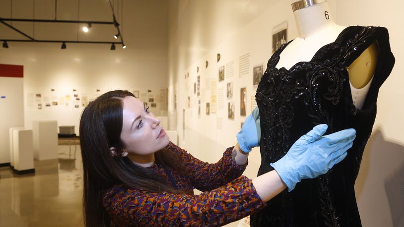 Hadley Drodge, assistant curator at the National Afro-American Museum & Cultural Center in Wilberforce, fits a dress that belonged to civil rights leader Anna Arnold Hedgeman for an anniversary exhibit, Color Outside the Lines: Celebrating Thirty Years at NAAMCC. LISA POWELL / STAFF