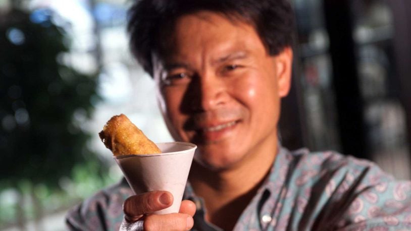 Art Chin holds an egg roll in a sno-cone cup.