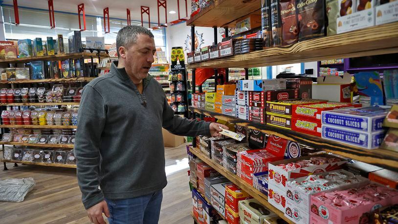 Chris Beers, owner of Grandpa Joe's Candy Shop, talks about the old fashioned candy the new Springfield candy shop will carry including pickle Monday, Nov. 14, 2022. BILL LACKEY/STAFF